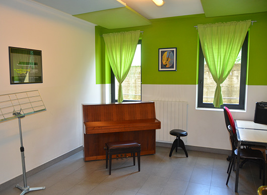 Aula con Pianoforte e quadro con scritto Jazz