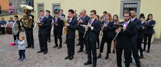 Banda Musicale Schierata in Servizio Religioso con Bimbo in prima fila che suona una Trombetta